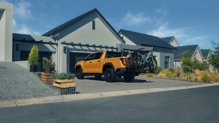 Toyota Hilux 2026 z rowerami na skrzyni przed domem, salon Toyoty Walder Zabrze