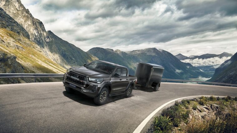 Toyota Hilux poprzedniej generacji z przyczepą na górskiej drodze, ostatnie egzemplarze w Toyota Walder Zabrze